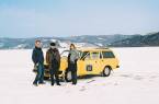 Three people and their car on the frozen expanse of ice on Lake Baikal