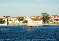 A dhow boat passes Stone Town in Zanzibar - Africa's Spice Island