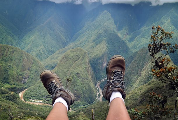 Hiker's shoes dangling above river
