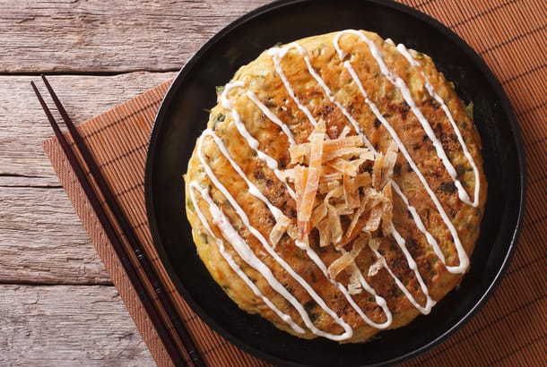 Okonomiyaki and chopsticks on mat