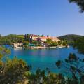 Aerial view of Dubrovnik, surrounded by water and filled with terracotta-roofed buildings