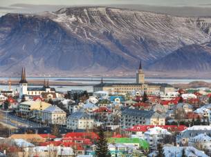 Aerial view of Reykjavik city with sea and Esja volcanic mountain range in background, Iceland
