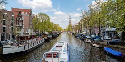 A sightseeing boat makes its way along the famous canals of Amsterdam