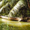 Wooden boat drifting along the river in Kumarakom