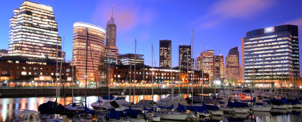 Bright lights of the cityscape behind boats on the hardbour in Buenos Aires