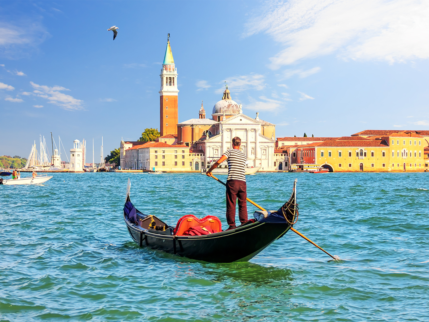 A gondolier and his gondola in Venice's Grand Canal, in front of Piazza San Marco