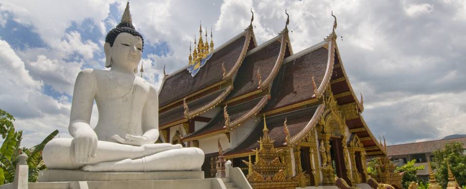 White Buddha statue in front of one of the many temples of Chiang Mai