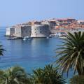 Aerial view of Dubrovnik, surrounded by water and filled with terracotta-roofed buildings