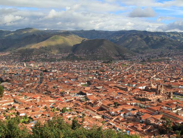 Looking out across the rooftops around the Plaza de Armas in Cuzco with the Andean mountains in the 