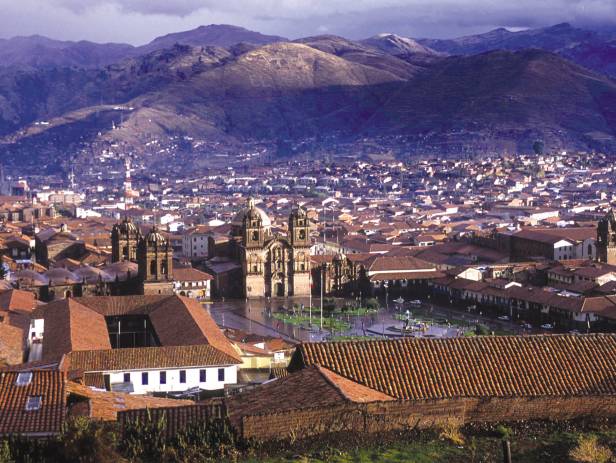 Looking out across the rooftops around the Plaza de Armas in Cuzco with the Andean mountains in the 