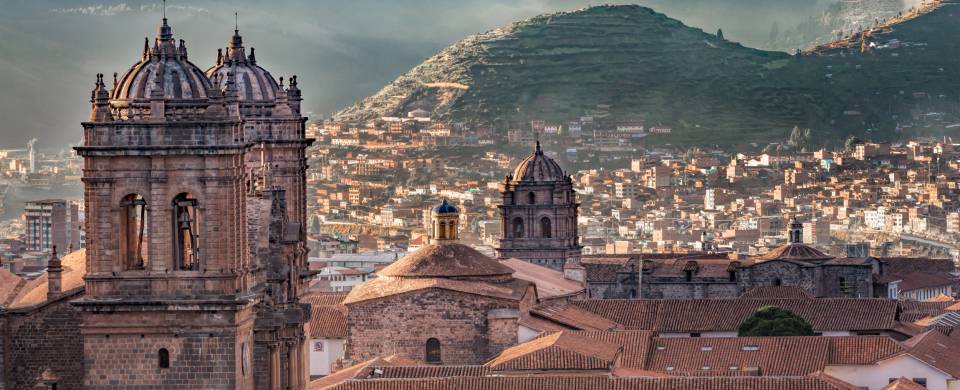 Looking out across the rooftops around the Plaza de Armas in Cuzco with the Andean mountains in the