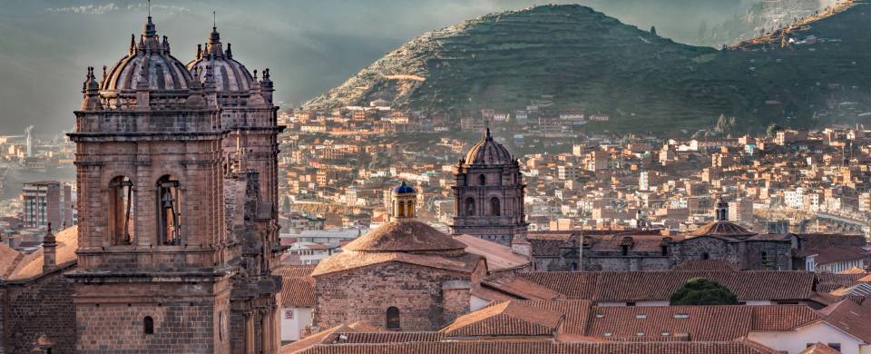 Looking out across the rooftops around the Plaza de Armas in Cuzco with the Andean mountains in the 