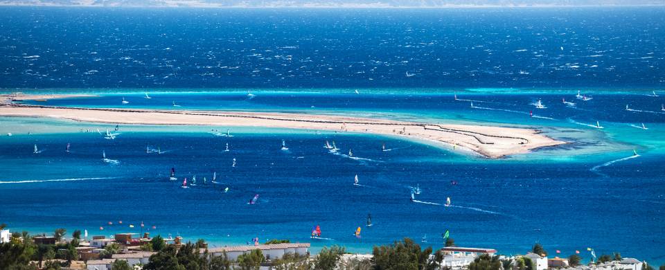 Wind surfers scattered across the dazzling blue lagoon in Dahab