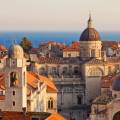 Aerial view of Dubrovnik, surrounded by water and filled with terracotta-roofed buildings