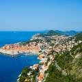 Aerial view of Dubrovnik, surrounded by water and filled with terracotta-roofed buildings