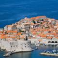 Aerial view of Dubrovnik, surrounded by water and filled with terracotta-roofed buildings