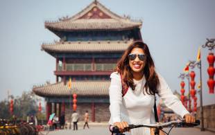 Female traveller cycling in China