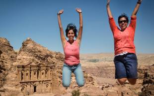 Female travellers jumping in the air at Petra, Jordan