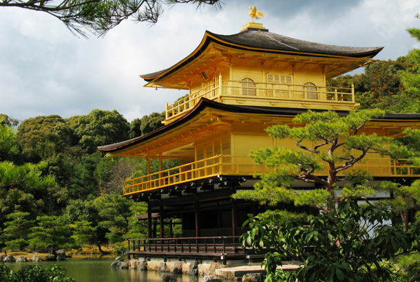 The golden temple surrounded by tress in front of a lake