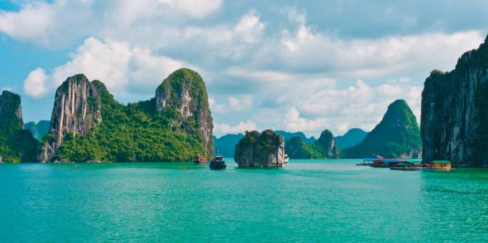 The karst islands of Halong Bay rising from the vivid green waters