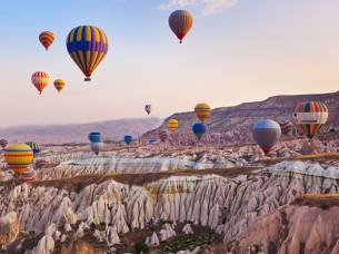 Hot air balloon flying over rock landscape at Cappadocia Turkey