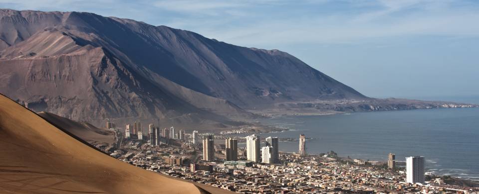 Sand dunes behind the city of Iquique and the sea in front of it