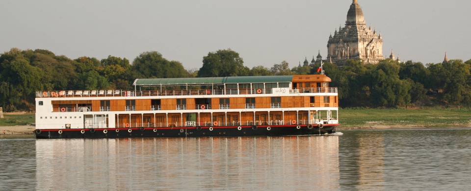 The RV Paukan cruise boat plies its course on the Irrawaddy River with Buddhist stupas as a backdrop