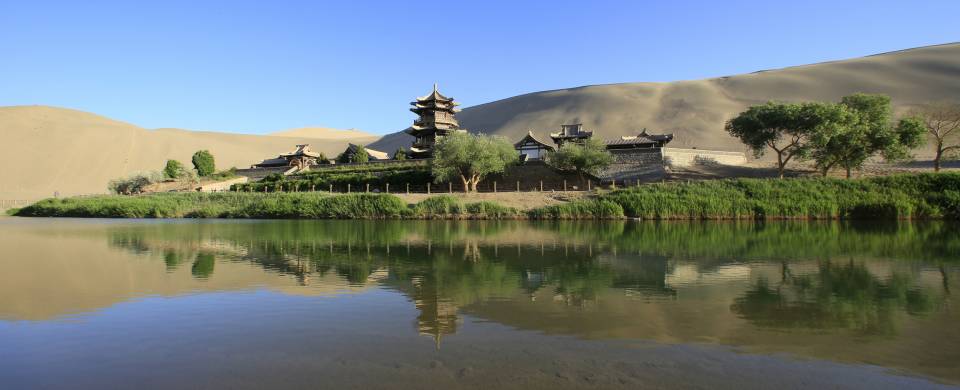 A temple standing majestically next to a lake in Jiayuguan