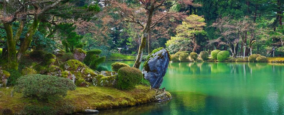 Stunning green lake surrounded by verdant vegetation in Kanazawa