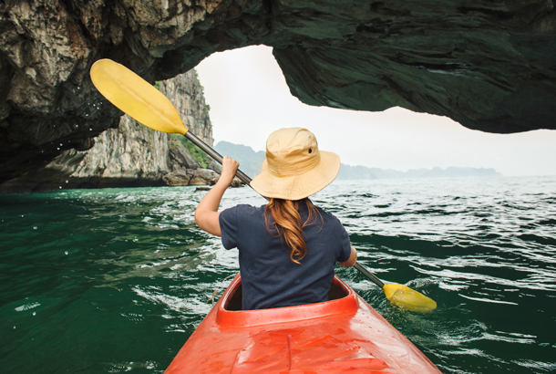 Solo female traveller kayaking in Halong Bay, Vietnam