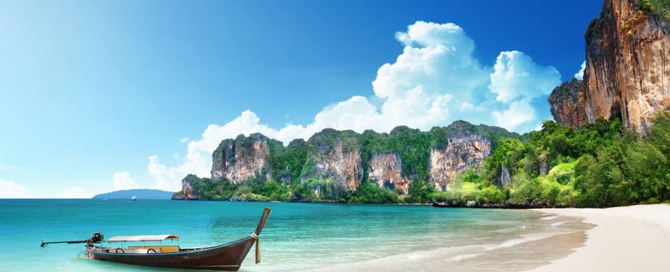 Traditional Thai boat on the crystal clear water at the beach in Krabi