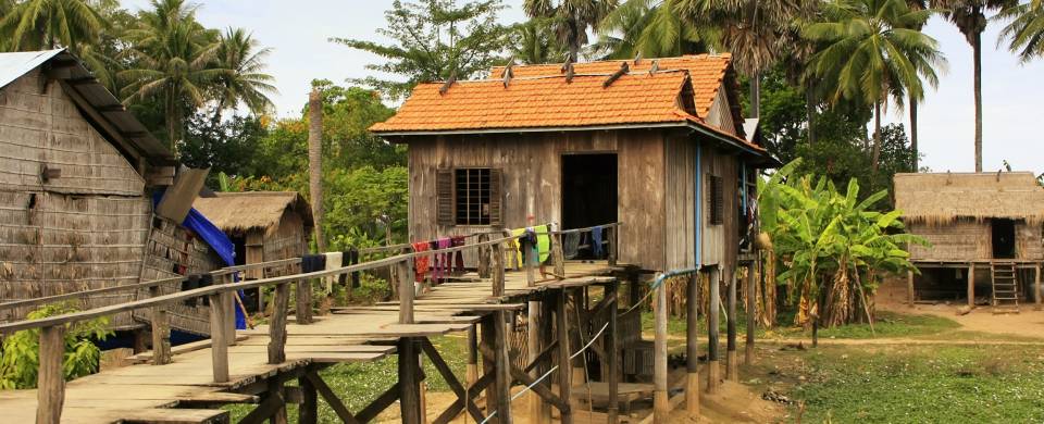 Wooden house on stilts with a rickety boardwalk in Kratie