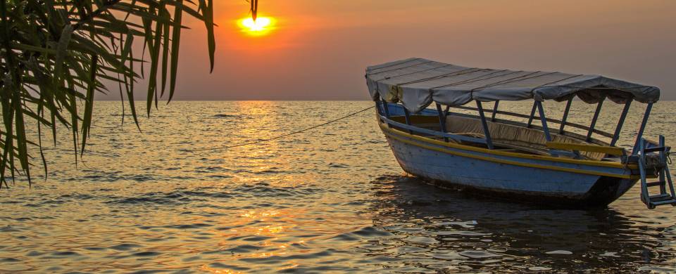 Boat on the water in front of the sunset at Lake Victoria