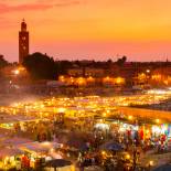 The sun begins to set over the twinkling lights of djemaa el fna square in Marrakech