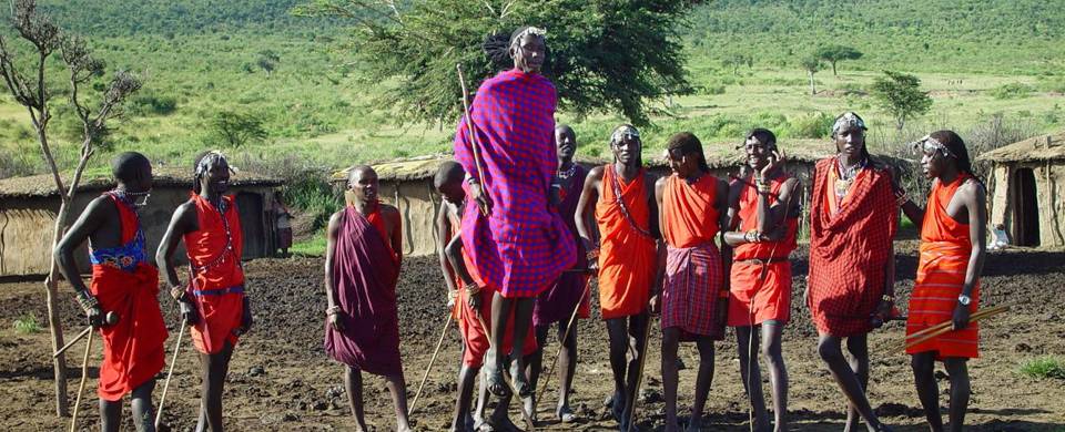 Masai Mara tribespeople standing in a row wearing colourful clothes