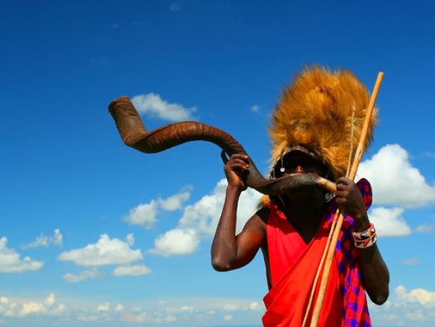 Masai Mara tribespeople standing in a row wearing colourful clothes