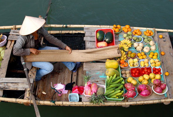 a man on a boat selling fresh fruit