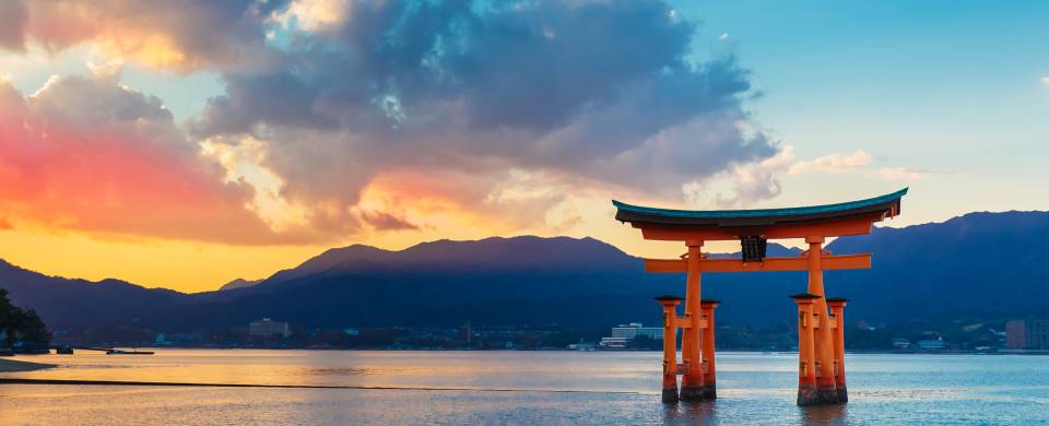 Sunset behind the iconic Miyajima monument that stands in the water