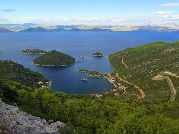 Aerial view of Dubrovnik, surrounded by water and filled with terracotta-roofed buildings