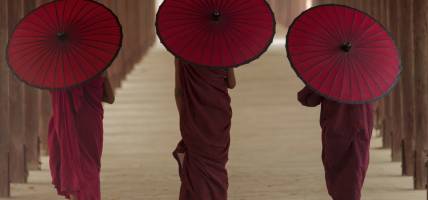 Monks walking with parasols in Myanmar - Southeast Asia - On The Go Tours