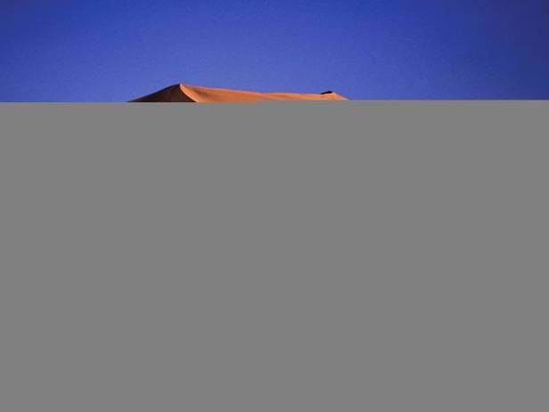 Orange sand dunes and rocky mountains at Namib Naukluft National Park