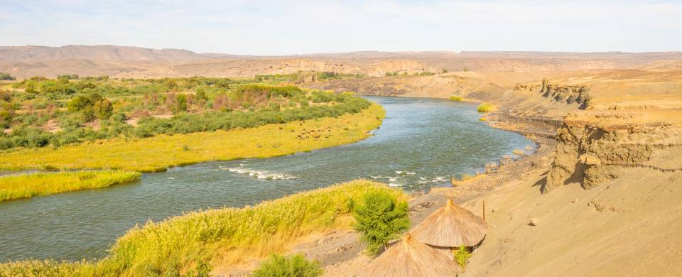 Stretch of the Orange River fringed with sandy and grassy landscape