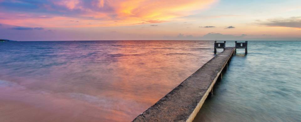 Stunning sunset, staining the sky all colours of the rainbow over a boardwalk stretching out in to t