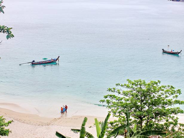 Traditional Thai boats rest in the clear waters of Phuket island