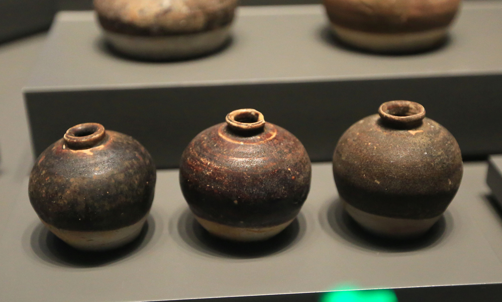 three pots in a museum case