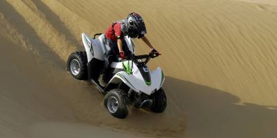 Young boy riding his quad bike in the desert