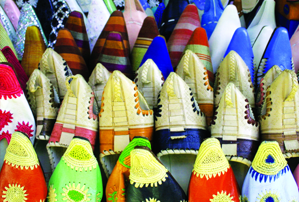 an array of multicolored traditional Moroccan shoes at a souk