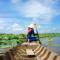 A Vietnamese woman rowing a boat in the lily-strewn waters of the Mekong Delta