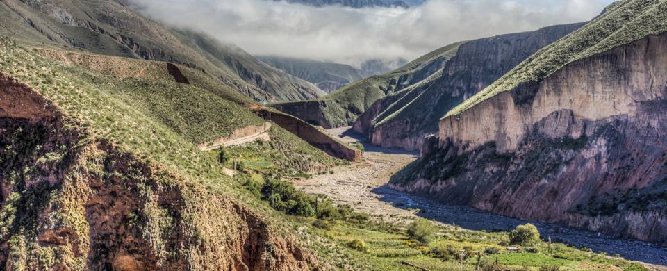 Winding road cutting through the rugged and rocky valley in Salta