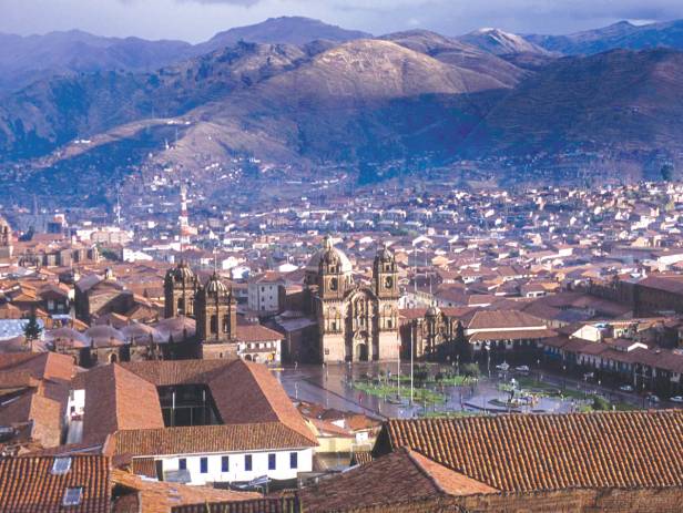 Looking out across the rooftops around the Plaza de Armas in Cuzco with the Andean mountains in the 